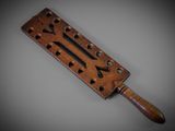 an old wooden tool with holes and holes on it