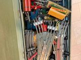 a metal box filled with assorted tools on the floor