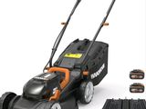 une tondeuse à gazon électrique Black & Decker avec ses batteries et son chargeur
