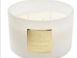 a close up of a white candle with a gold label on it