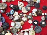 a pile of assorted buttons on a red surface
