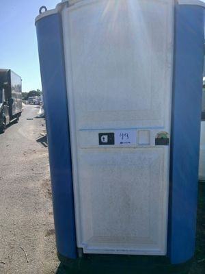 des toilettes portables bleues posées au bord de la route