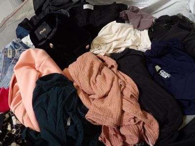 a pile of clothes that is on a bed