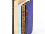 trois livres sont empilés sur une surface blanche