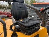 a yellow tractor with a black seat and a black bag on the back
