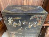 a black cabinet with a painting on it in a room