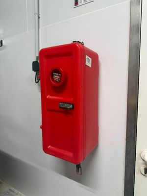 une borne d'incendie rouge fixée au mur d'une salle de bains