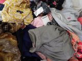 a pile of clothes that is sitting on a bed