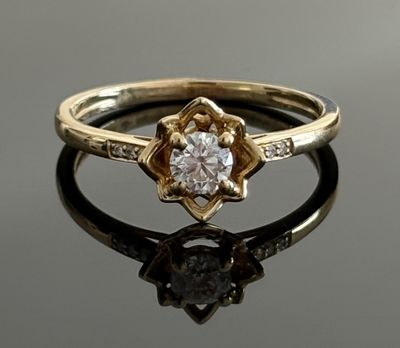 a close up of a diamond ring on a reflective surface