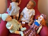four dolls sitting on a red chair in a room