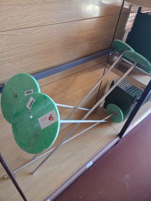 a green chair and a laptop on a stand