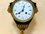 une horloge posée sur un support sur une table