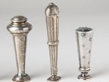 three silver vases sitting next to each other on a white surface