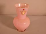 un vase rose orné d'un motif doré