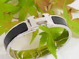 silver and black enamel bracelet with a square buckle on it