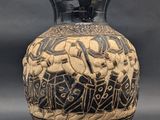 a black and white vase with a design on it