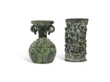 two green vases sitting next to each other on a white surface