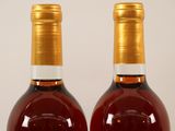 two bottles of wine are shown on a white surface