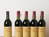 quatre bouteilles de vin sont alignées sur une table en bois