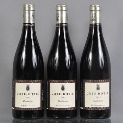 three bottles of wine are lined up on a table
