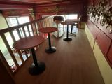 two tables and two stools in the corner of a room