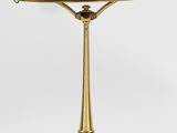 une lampe de table en laiton surmontée d'un abat-jour violet