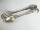 two silver spoons and a fork on a table