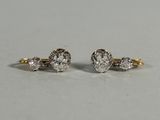 a pair of diamond earrings on a white surface