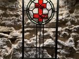 a stained glass window with a red cross on it