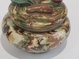 a small jar with a lid that has a design on it