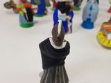 many figurines of people standing on a white surface