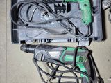 a green and black electric drill and other tools in a case