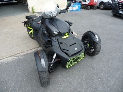 une photo d'une moto noire et verte garée sur un parking