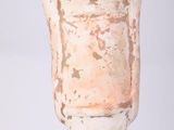a white vase with a wooden figure on it