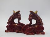 pair of red ceramic figurines with gold accents on white background