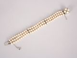 a close up of a white beaded necklace on a white surface