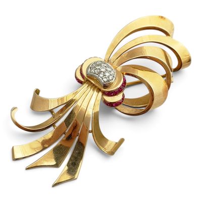 un gros plan d'une broche en or ornée d'un diamant rouge et blanc en son centre