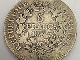 a silver coin with a wreath of flowers on it