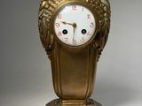 une horloge en or dont le cadran est orné de raisins
