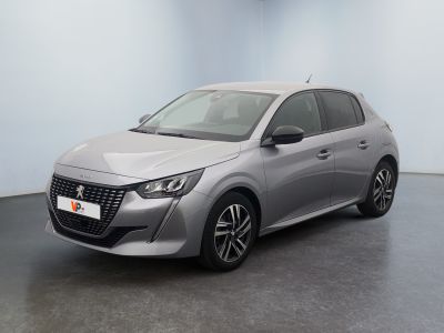 Une voiture argentée est garée dans une pièce au sol noir.