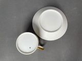a white cup and saucer sitting on a table