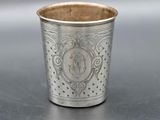 an old silver cup sitting on top of a table