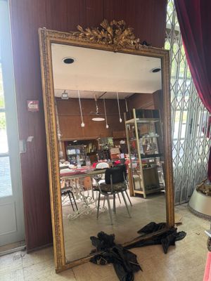 a large mirror in the middle of a room with red curtains