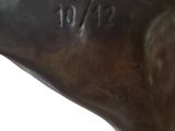 bronze statue of a dog with a tag on it ' s collar
