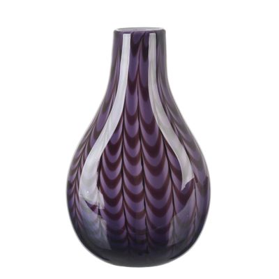 a purple vase that is sitting on a white surface