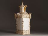 a white vase with a statue on top of it