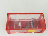 a red toy car in a clear box on a white surface
