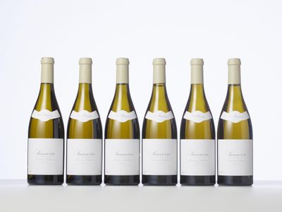 quatre bouteilles de vin blanc alignées les unes à côté des autres