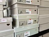 boxes are stacked on a shelf in a storage room with labels on them