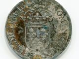 une vieille pièce d'argent surmontée d'une couronne